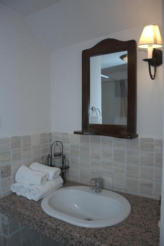 a bathroom sink with a mirror and towels on a counter at Αργουλιάς in Tzermiádon