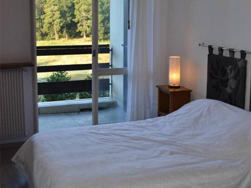 布齊耶比利牛斯2000的住宿－Appartement Bolquère-Superbolquère, 2 pièces, 6 personnes - FR-1-592-20，一间卧室配有一张带灯和窗户的床