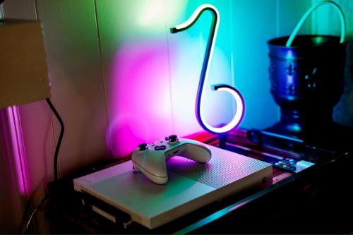 a video game controller sitting on top of a table at Giggling Creek Cottage - BedJet! King Sized! Gazebo, 45 Acres, Arcades, Nintendo, more in Henry