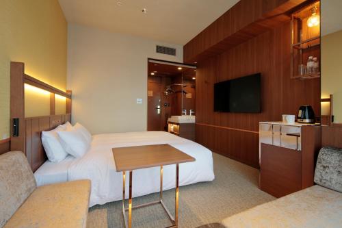 a hotel room with a bed and a television at Candeo Hotels Osaka Shinsaibashi in Osaka