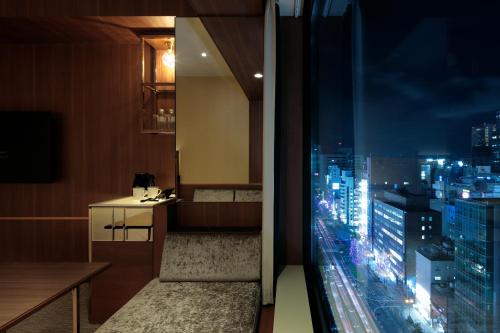 a room with a view of a city at night at Candeo Hotels Osaka Shinsaibashi in Osaka