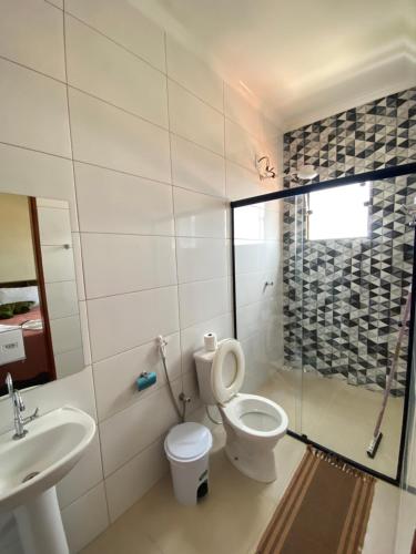 a bathroom with a toilet and a sink and a shower at Pousada Véu de Noiva in São Thomé das Letras