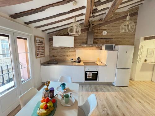 a kitchen with a table and a white refrigerator at APARTANENTO LOFT LAUREL coqueto con Wifi y aire in Logroño