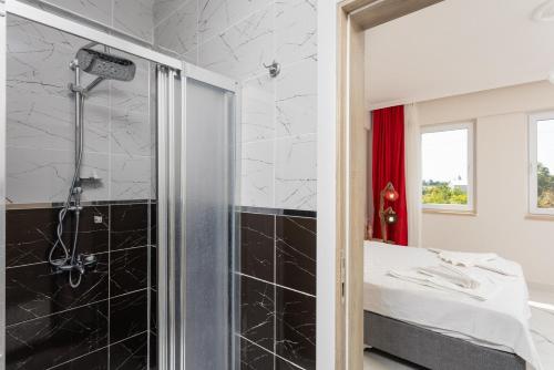y baño con ducha y azulejos blancos y negros. en Villa Azalea 1, en Ortaca