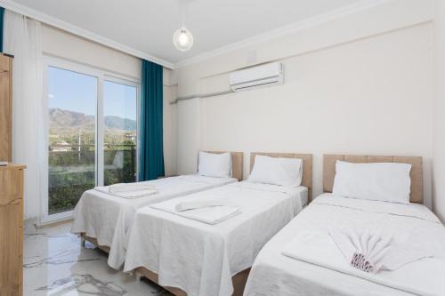 2 camas en una habitación con ventana en Villa Azalea 1, en Ortaca