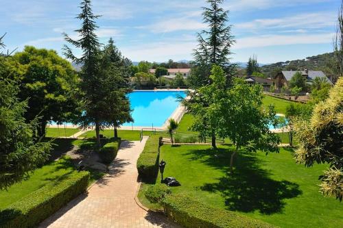 een uitzicht over een zwembad in een park bij Casa Rural, “El Andador” in Hoyo de Pinares