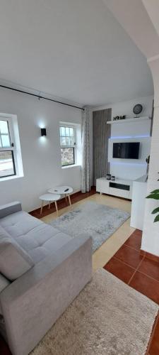 a living room with a couch and a tv at Alojamento Bela Vista in Lajes do Pico