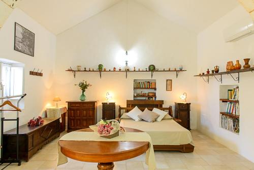 a bedroom with a bed and a table and shelves at Masseria Pozzo Tre Pile in Martina Franca