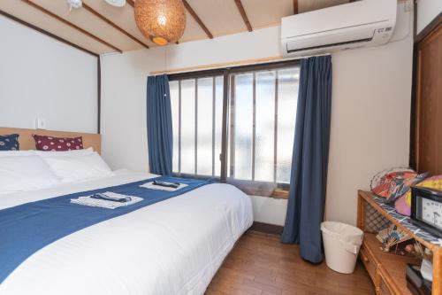 une chambre avec un lit et une grande fenêtre dans l'établissement GuestHouse OneWorld Shijo四条京町屋, à Kyoto