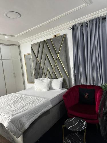 ein Schlafzimmer mit einem Bett und einem roten Stuhl in der Unterkunft Break or Makeup in Lekki