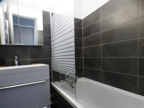 een badkamer met een bad en een wastafel bij Appartement Les Saisies, 1 pièce, 4 personnes - FR-1-594-148 in Hauteluce
