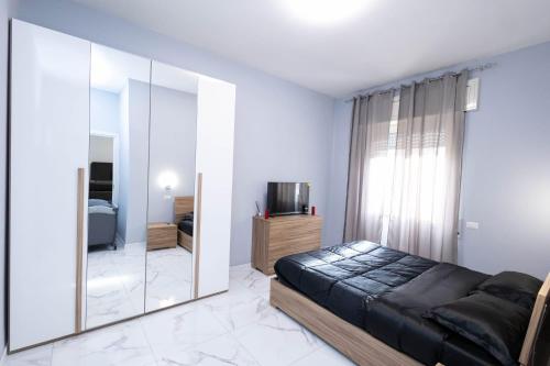 um quarto com uma cama e um espelho grande em CF Luxury House em Lido di Ostia