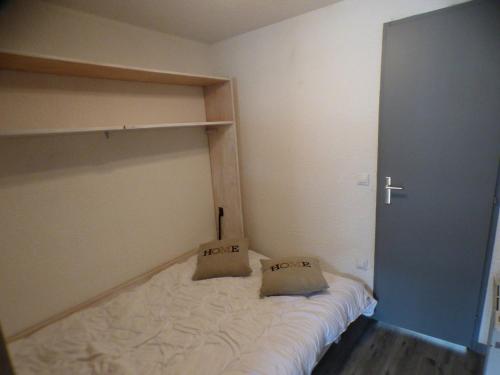 une chambre avec un lit avec deux oreillers dessus dans l'établissement Studio Cabine aux Saisies, Balcon Sud/Est, 4 Pers, Centre et Commerces Proches, Label Qualité 3 Diamants - FR-1-594-148, à Hauteluce