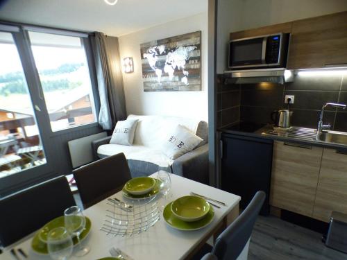 une cuisine et une salle à manger avec une table et une cuisine, ainsi qu'une chambre avec dans l'établissement Studio Cabine aux Saisies, Balcon Sud/Est, 4 Pers, Centre et Commerces Proches, Label Qualité 3 Diamants - FR-1-594-148, à Hauteluce