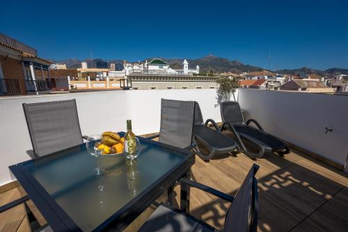 a table with a bowl of fruit on a balcony at Apartamentos Kronox in Nerja