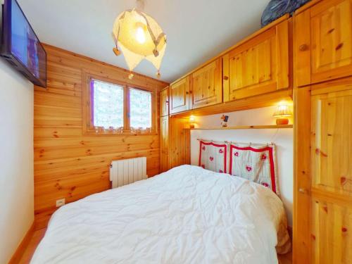- une chambre avec un lit, une télévision et des placards en bois dans l'établissement Appartement en Forêt des Rennes II, 2 Pièces + Cabine, Balcon, 4 Pers., Proche ESF, Classé 2 Étoiles - FR-1-594-168, à Hauteluce