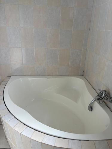 y baño con bañera y grifo. en TT’s self-catering apartments, en Qumbu