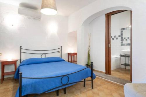 a bedroom with a bed with a blue blanket at Vicolo della Luna in Castelsardo