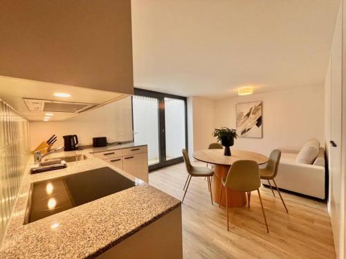 a kitchen and living room with a table and a couch at The R Apartment Roggen, new, Parking, washing machine in Kestenholz
