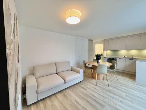 a living room with a couch and a table at The R Apartment Roggen, new, Parking, washing machine in Kestenholz