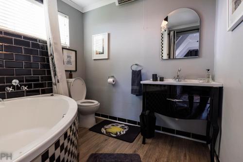 a bathroom with a tub and a sink and a toilet at The Red Door in Clarens