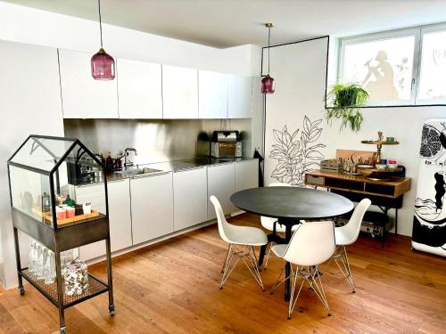 a kitchen with a table and chairs in a room at AareSüdhang Loft Bern - Yacht feeling in Bern