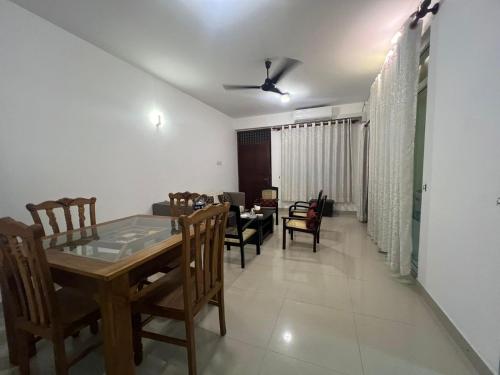 a dining room and living room with a table and chairs at Skylar apartment in Kalubowila West