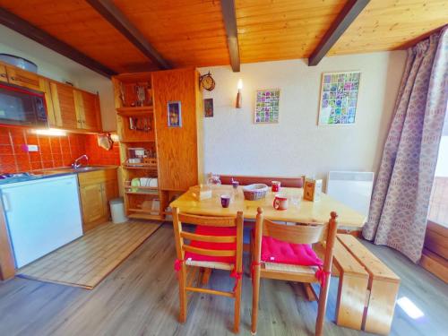 une cuisine avec une table et des chaises dans une pièce dans l'établissement Studio cosy 4 pers avec balcon, centre Les Saisies - FR-1-594-196, à Hauteluce