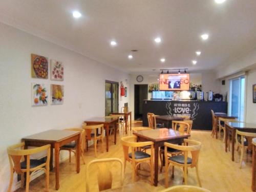 un restaurant avec des tables et des chaises en bois et un comptoir dans l'établissement HOTEL ROMA DE TANDIL, à Tandil