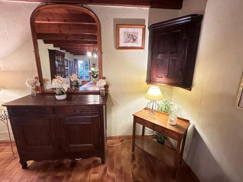 um quarto com uma cómoda de madeira e um espelho em Le Mesnil Gonfroy, A Haven Of Tranquility em Hambye