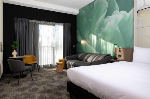 a hotel room with a bed and a couch at Otium Hotel Roosendaal in Roosendaal