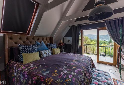 a bedroom with a large bed and a balcony at The Red Door in Clarens