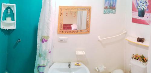 un baño con lavabo y espejo en Buganvilla Guest House, en Ballenita