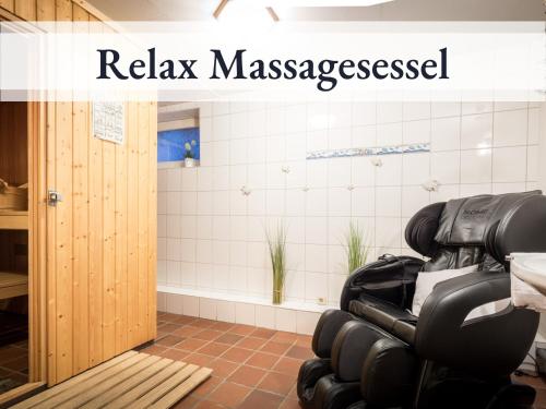una habitación con una sala de relajación con un cartel de sesión de masaje en Blumenvilla 9 mit Sauna und Garten, en Schneverdingen