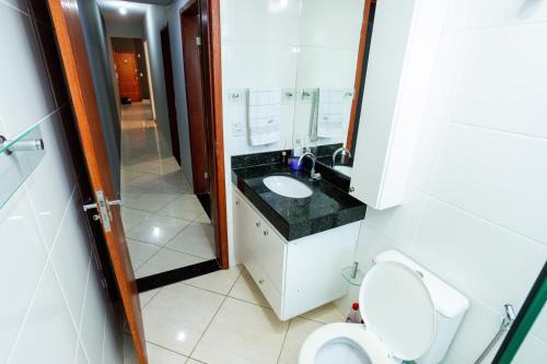 a bathroom with a sink and a toilet and a mirror at Aconchego Veredas II in Viçosa