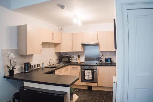 a kitchen with wooden cabinets and a black counter top at The Scot in Perth