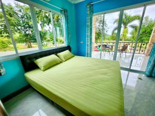 uma cama num quarto com uma grande janela em บ้านกลางหุบเขา แก่งกระจาน em Kaeng Krachan