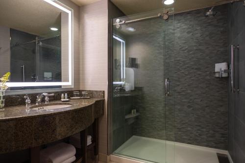 a bathroom with a glass shower and a sink at Renaissance Dallas Richardson Hotel in Richardson