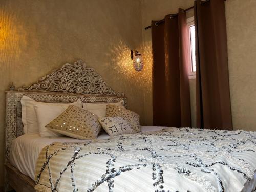 a bedroom with a bed with pillows and a window at Riad with 3 Swimming Pools in Marrakesh