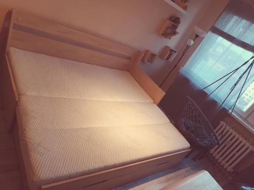 uma cama vazia num quarto com janela em Slunný byt v 7 patře em Praga