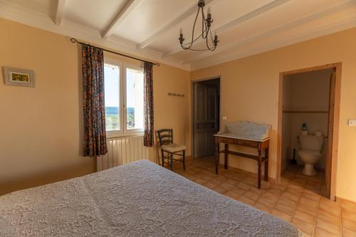 1 dormitorio con cama, escritorio y ventana en Chambres d'hôtes La Clape, en Vinon-sur-Verdon
