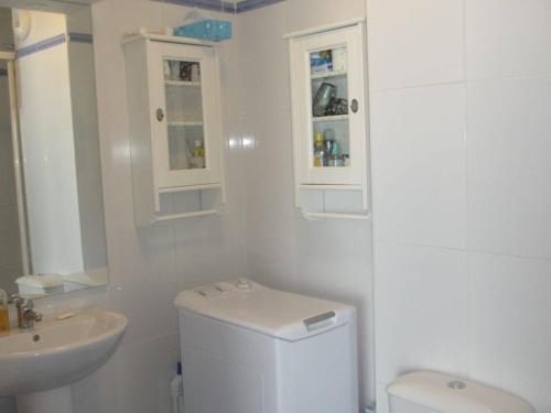 une salle de bain blanche avec des toilettes et un lavabo dans l'établissement Appartement cosy 6 pers. à Arette, 2 chambres, kitchenette, lave-vaisselle, lave-linge, casier à skis - FR-1-602-51, à Arette