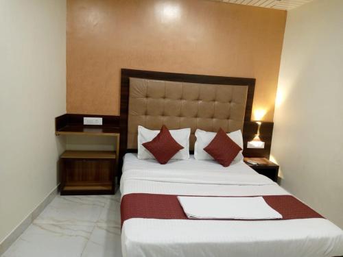 a bedroom with a large bed with red and white pillows at TRI HOTEL in Mumbai