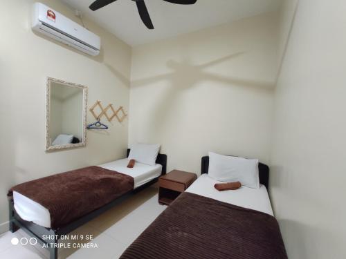 a room with two beds and a mirror at MUSLlM ONLY Pool Wifi 3 aircond room Hospital Sultanah Bahiyah in Alor Setar