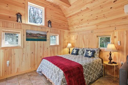 a bedroom with a bed in a wooden room at Avonlea Forest Hill Cottages in New Glasgow