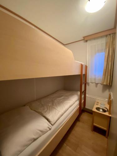 a bunk bed in a small room with a table at Chalet Seazon R23 in Buren