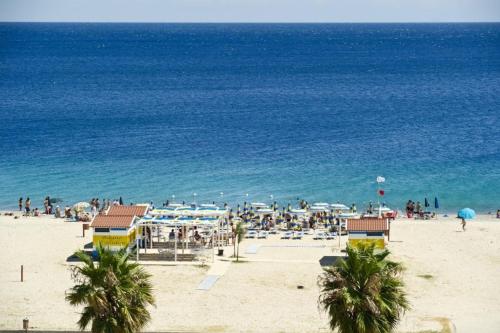 Grupa ludzi na plaży w pobliżu oceanu w obiekcie Hotel Poseidon w mieście Corigliano Calabro