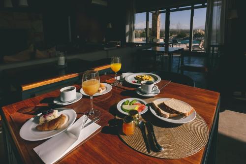 a table with plates of food and glasses of orange juice at Rosell Boher Winery Lodge & Spa in Agrelo