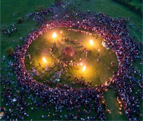 a large crowd of people standing in a circle with lights at Shannon Estuary Glamping in Effernan