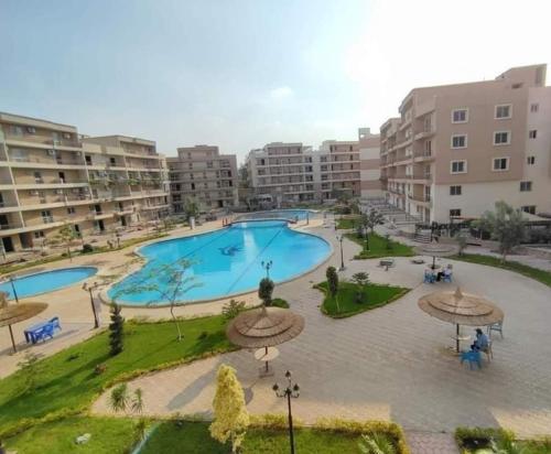 an apartment complex with a large swimming pool at Pyramids and Museum Resort /villa in Giza